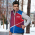A red and blue custom puffer vest featuring a logo, worn by a model in a winter setting.