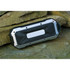 A rugged, waterproof Bluetooth speaker in black and silver, resting on a rock surface.