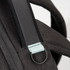 A black backpack strap featuring a light blue accent and a metal loop. The material has a textured finish.
