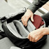 A black backpack is open, revealing compartments filled with clothing and an inner mesh pocket.