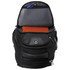 A black backpack with a spacious interior, showing an orange notebook and a pocket for storage. It features a logo.