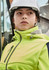 A women's bright yellow stretch softshell jacket with a hood, worn by a person in a hard hat.
