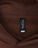 A brown unisex oversized hoodie with a tag displaying size information and a logo.
