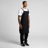 A black Carrie apron, featuring adjustable straps, displayed on a model in a standing pose against a plain background.