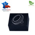 A round black phone holder packaged in a dark box, featuring a simple illustration and a logo.