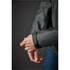 A grey jacket with a fitted cuff, showcasing a sleek design and subtle branding on the sleeve.