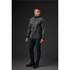 A man wearing a grey softshell jacket stands against a dark background, showcasing a sleek design and fitted style.