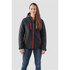 A woman wearing a black and red insulated softshell jacket with a hood and multiple zip pockets.