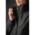 A close-up of a woman's Montauk System Jacket in dark grey, featuring a zipped collar and button details.