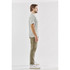 A light grey men's t-shirt displayed on a model standing side-on, paired with olive green trousers. The shirt has a logo.