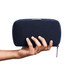 A hand holding a dark navy tech kit with a zippered closure, featuring a minimalist design and branding.