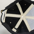 An organic cap featuring a black exterior with a light-coloured lining and internal stitching details.