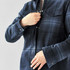 A navy and grey plaid jacket with a Sherpa lining, featuring snap closures and two chest pockets.