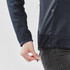 A close-up of a woman's hand adjusting the drawstring of a navy knit jacket with a zipper pocket.