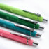 A set of four soft-touch pens in green, teal, dark green, and pink, each with a silver clip and branding.