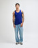 A unisex fine jersey tank in blue, paired with black cargo pants and green and white sneakers. Features a branding logo.