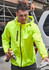 A man wearing a bright yellow unisex super light packable rain jacket, holding a drill and working outdoors.