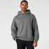 A grey hoodie with a relaxed fit and a hood, featuring long sleeves. The model is standing with a neutral background.