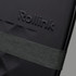 A close-up of a black suitcase featuring a textured surface and an attached dark green strap. It has a logo visible.