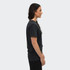 A faded unisex T-shirt in dark grey, displayed on a model from the side. Features a brand logo.