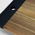 A wooden serving board with a textured black edge and a circular cutout, showcasing natural wood tones.