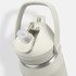 A drink bottle in light grey with a flip straw lid and a handle. It features a logo on the side.