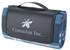 A folded blue picnic rug with a black carrying handle and a logo on the surface.