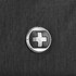 A close-up of a circular logo on a textured black fabric, featuring a distinctive design.