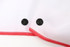 A beach towel in white with a red trim and two black snaps for fastening.