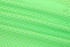 A close-up of vibrant green fabric, featuring a textured pattern, ideal for race staff bibs.
