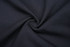 A black fabric with a smooth texture, arranged in a spiral pattern, suitable for trousers or school wear.
