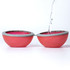 A red and grey reusable water balloon split in half, with water being poured into one half.