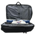 A black backpack with an open interior, featuring grey lining and neatly arranged items including a towel and a shirt.