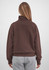 A brown 1/4 zip jumper with a relaxed fit, featuring a high collar and long sleeves. Grey pants are worn with it.