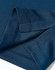 A close-up of a navy blue sustainable jacquard knit polo, highlighting the fabric texture and stitching details.