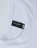 A white long-sleeve tee with a round neckline, featuring a label and a logo.