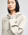 A light grey hooded sweatshirt featuring a kangaroo pocket and a logo on the sleeve.