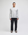 A grey crew sweatshirt worn by a model, paired with black trousers, featuring a subtle logo.
