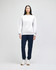 A model wearing a grey crewneck sweatshirt and navy tracksuit pants, standing against a plain background.