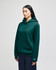 A green hooded sweatshirt with a front pocket and a logo on the sleeve, modelled by a woman.