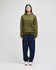 An adult pullover hooded sweatshirt in olive green, worn with navy trousers, featuring a logo.