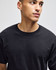 A black short-sleeve t-shirt with a round neck. The model is looking to the side, showcasing the shirt's fit.