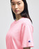 A pink Champion adult short-sleeve T-shirt featuring a logo on the sleeve.