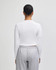A white long-sleeve cropped fitted t-shirt viewed from the back, paired with grey pants.