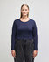 A long-sleeved, fitted crop top in navy blue, paired with high-waisted dark jeans. The top features a round neckline and has a logo.