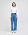 A cropped white hoodie with a drawstring hood paired with blue jeans, modelled by a woman. The hoodie features a logo.