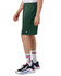 Green sports shorts with pockets, featuring a logo, displayed on a model alongside sneakers and socks.