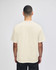 A beige Champion Adult Heritage Jersey T-Shirt viewed from the back, featuring short sleeves and a logo.