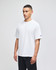 A white Champion Adult Heritage Jersey T-Shirt on a model, featuring a logo on one sleeve.