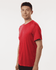 A man in a bright red performance T-shirt, featuring a logo, standing against a white background.
